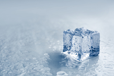 Photo of Crystal clear ice cube on grey background, closeup. Space for text