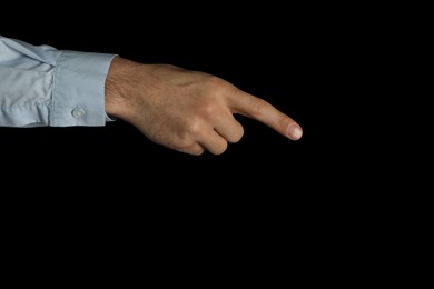 Man pointing at something on black background, closeup