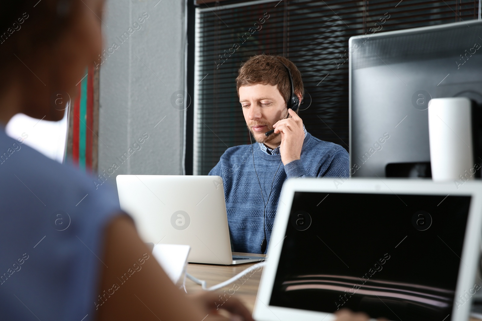 Photo of Technical support operator with headset at workplace