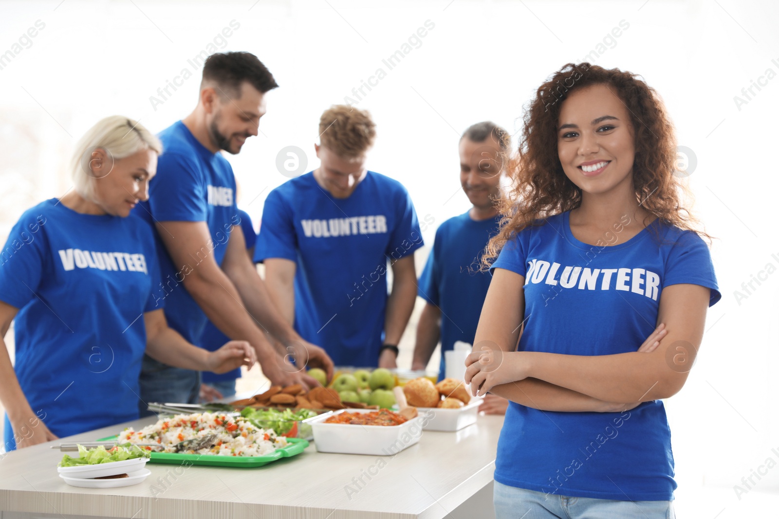 Photo of Team of volunteers near table with food indoors