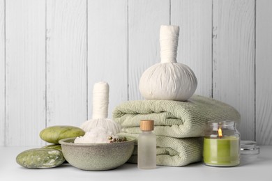 Photo of Composition with different spa products and candle on white table against wooden background. Space for text