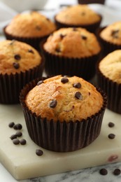 Photo of Delicious sweet muffins with chocolate chips on table, closeup