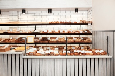 Photo of Showcase with different pastries in bakery shop