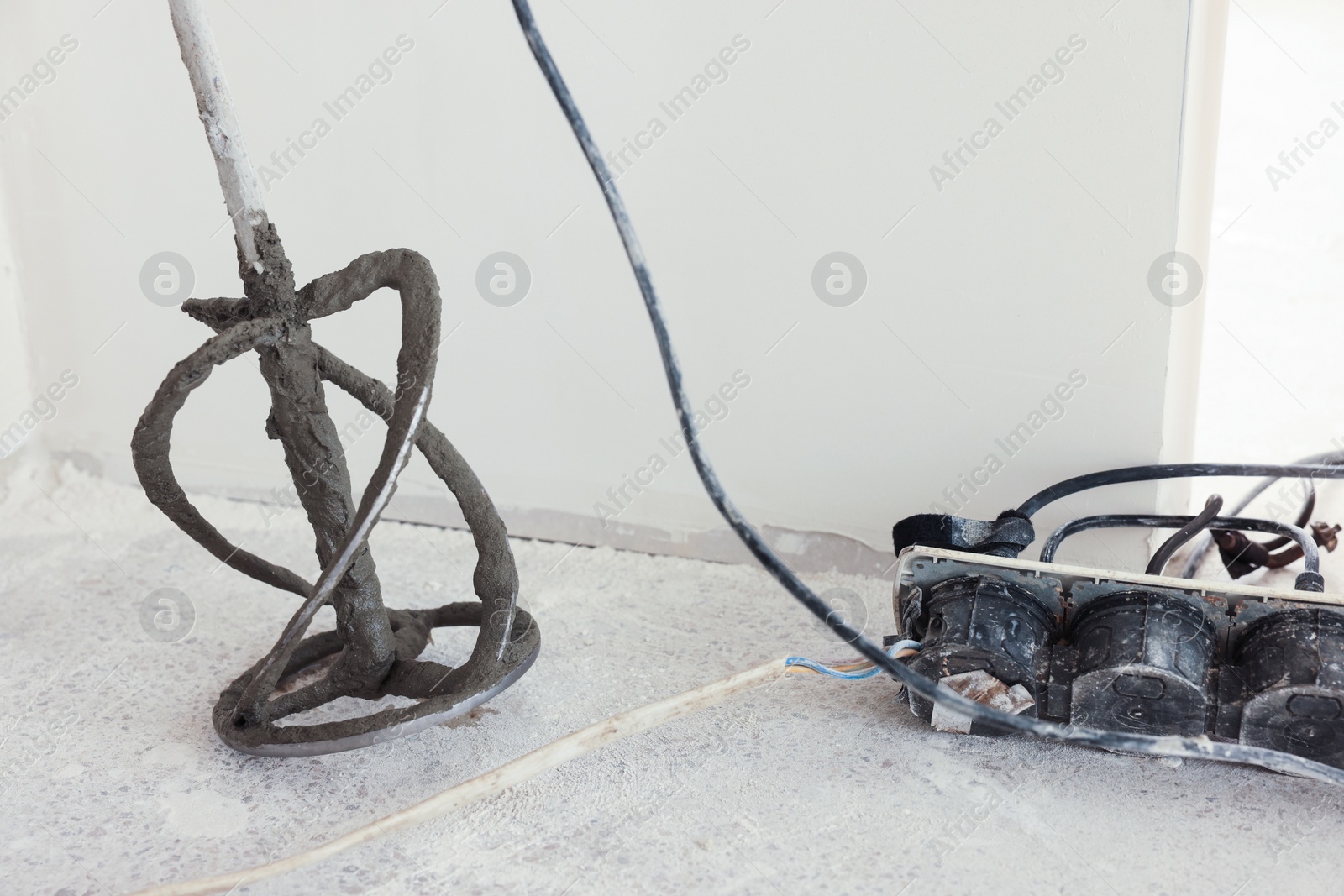 Photo of Power mixer on floor near wall indoors. Tiles installation process