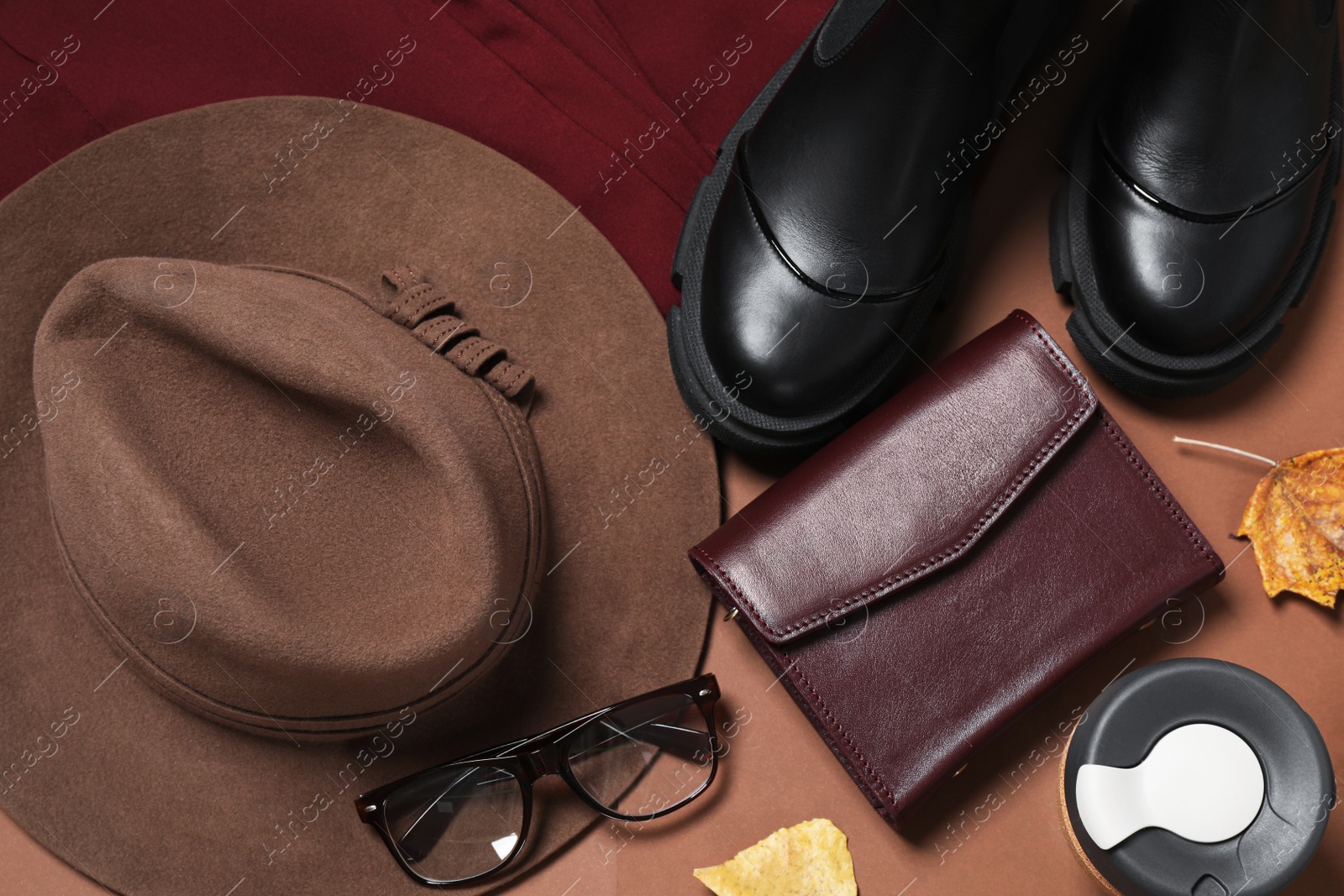 Photo of Flat lay composition with stylish hat on brown background