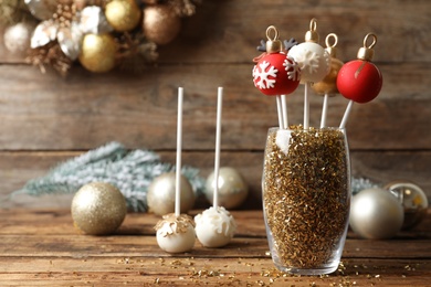 Photo of Composition with delicious Christmas ball cake pops on wooden table
