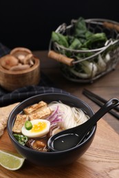 Photo of Delicious vegetarian ramen in bowl on wooden table