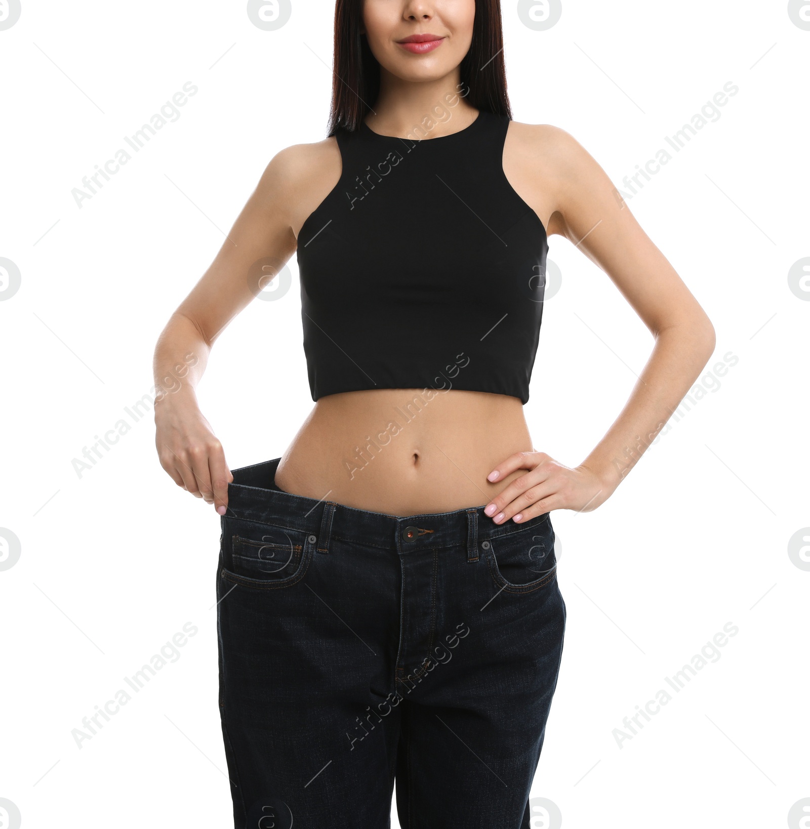 Photo of Young woman wearing big jeans after weight loss on white background, closeup