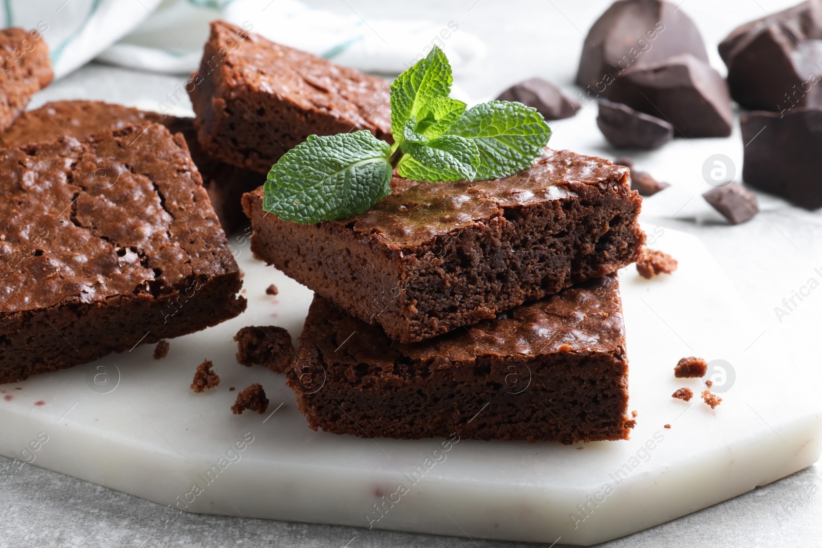 Photo of Delicious chocolate brownies with fresh mint on grey table