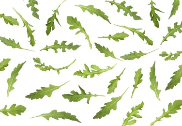 Image of Many green arugula leaves falling on white background