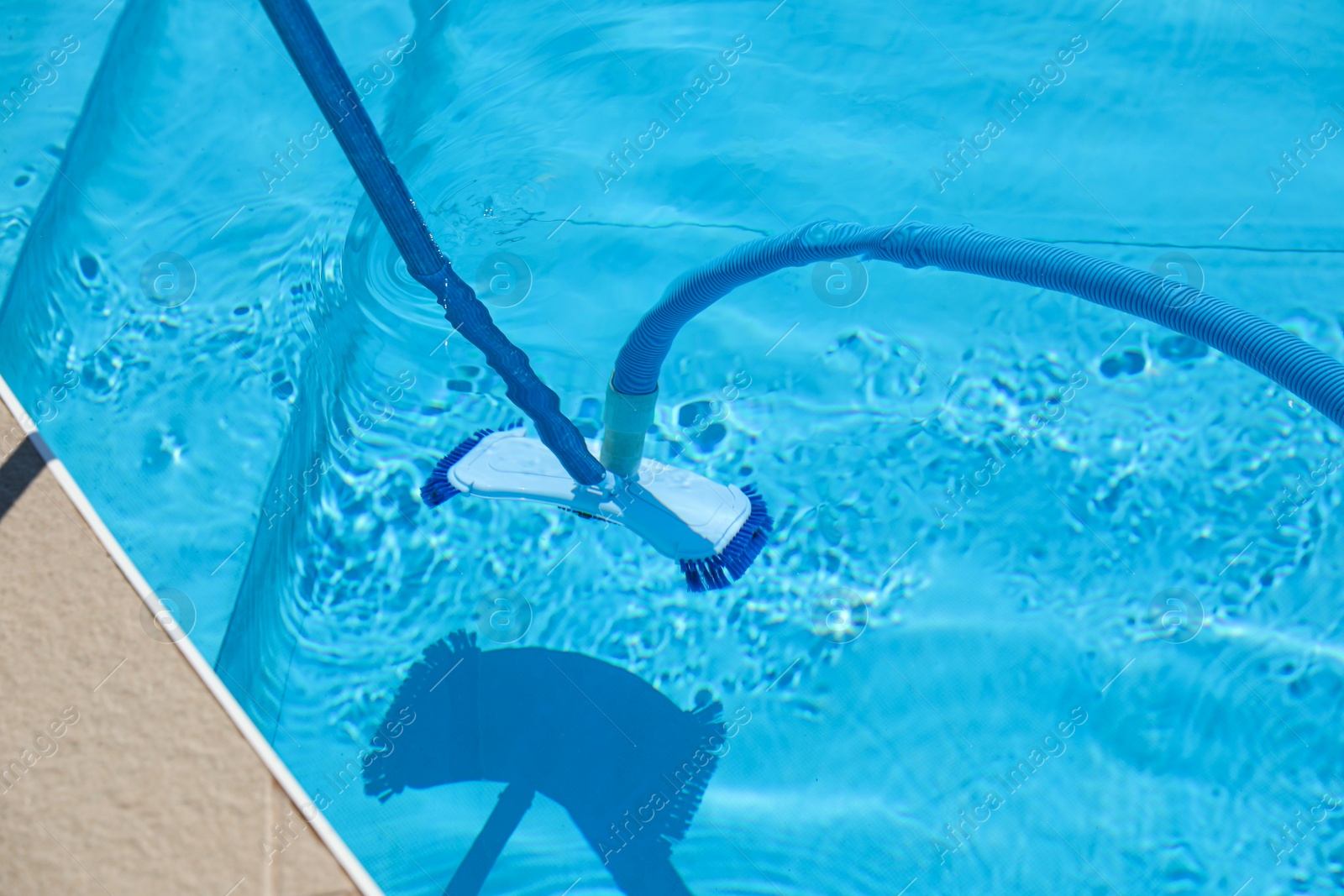 Photo of Cleaning outdoor pool with underwater vacuum, closeup