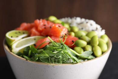 Delicious poke bowl with lime, fish and edamame beans, closeup view