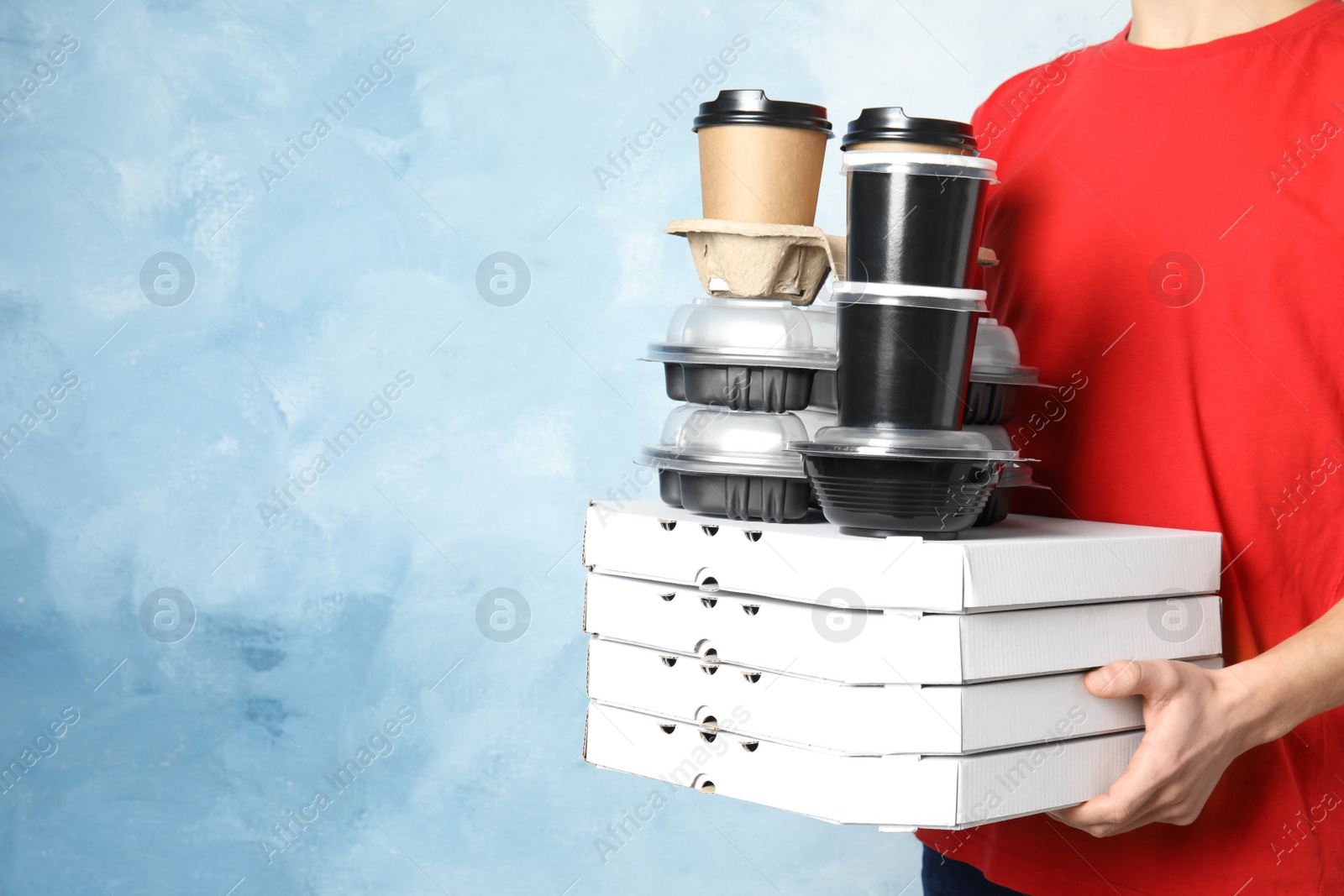 Photo of Courier with stack of orders on color background, space for text. Food delivery service