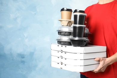 Courier with stack of orders on color background, space for text. Food delivery service