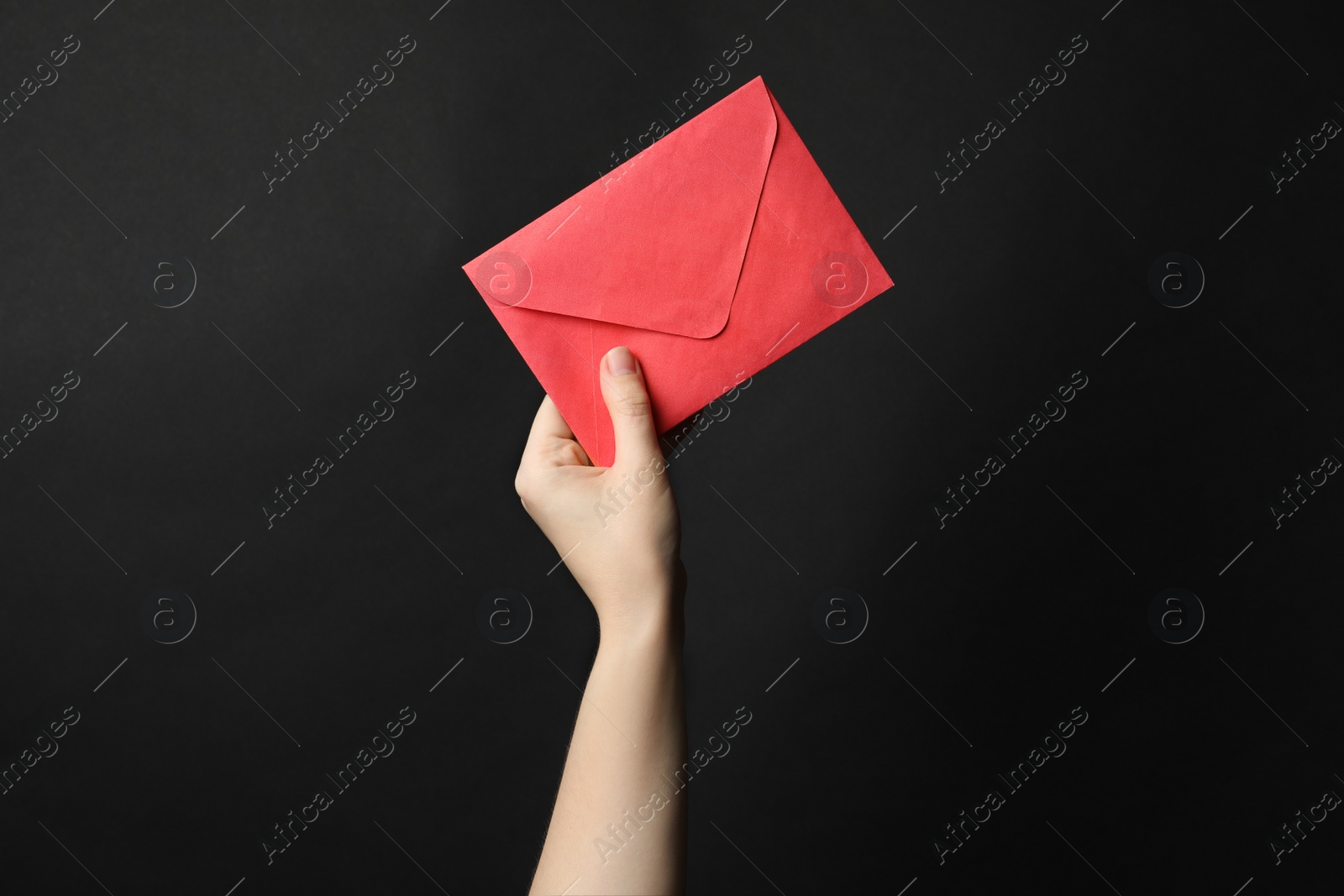 Photo of Woman holding red paper envelope on black background, closeup