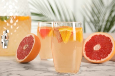 Delicious refreshing drink with orange and grapefruit on white marble table