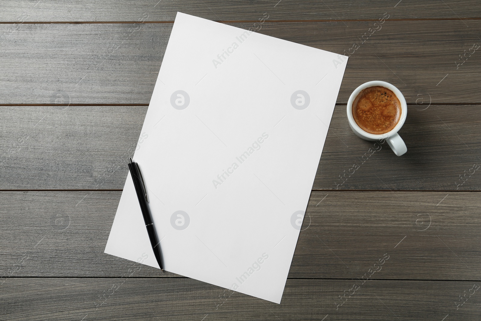 Photo of Blank paper sheet, pen and cup of coffee on wooden table, flat lay. Space for text