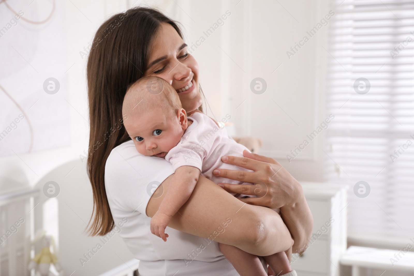 Photo of Young woman with her little baby at home