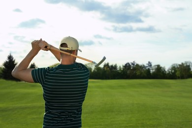 Photo of Man playing golf on green course, back view. Space for text