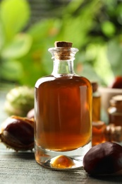 Photo of Chestnuts and bottle of essential oil on blue wooden table