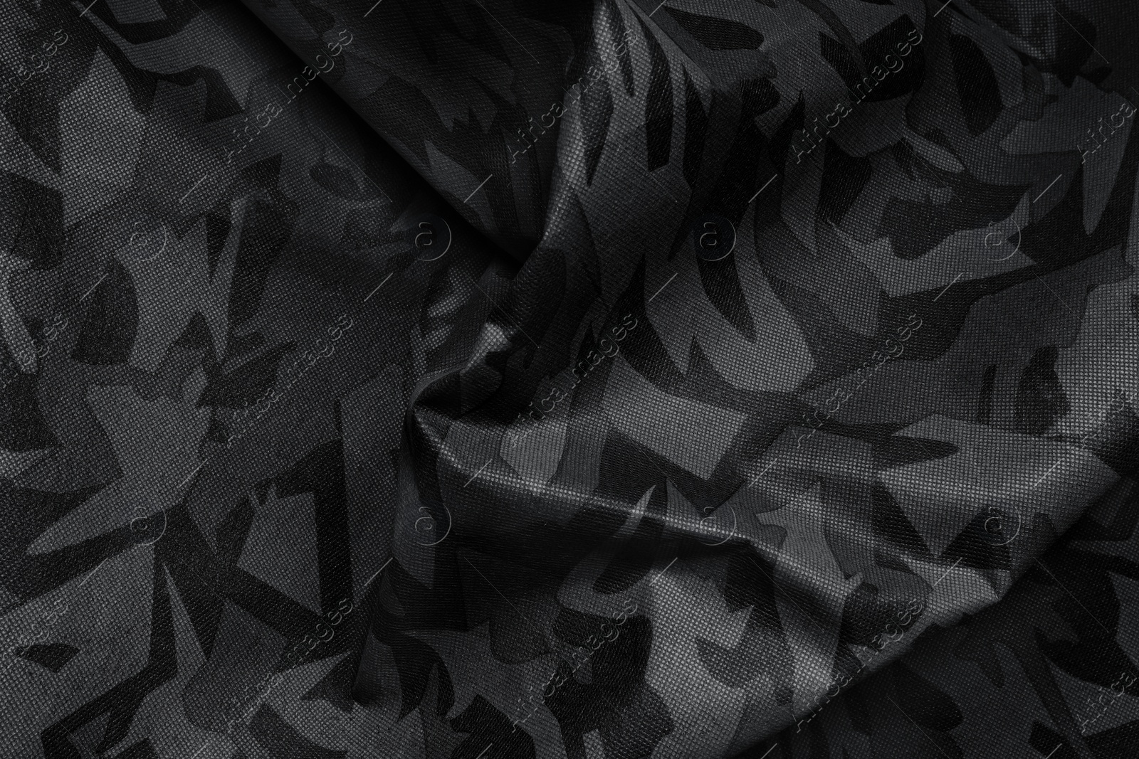 Image of Texture of crumpled camouflage fabric as background, top view. Black and white effect