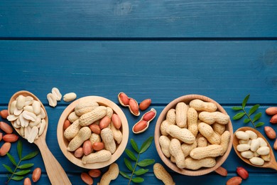 Photo of Fresh peanuts and twigs on blue wooden table, flat lay. Space for text