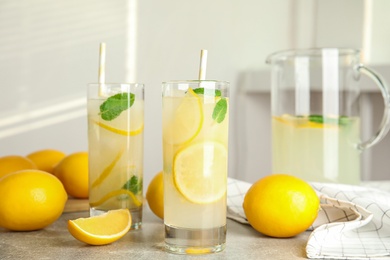 Photo of Cool freshly made lemonade and fruits on grey table