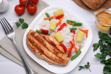 Grilled chicken breast and rice served with vegetables on white table, flat lay