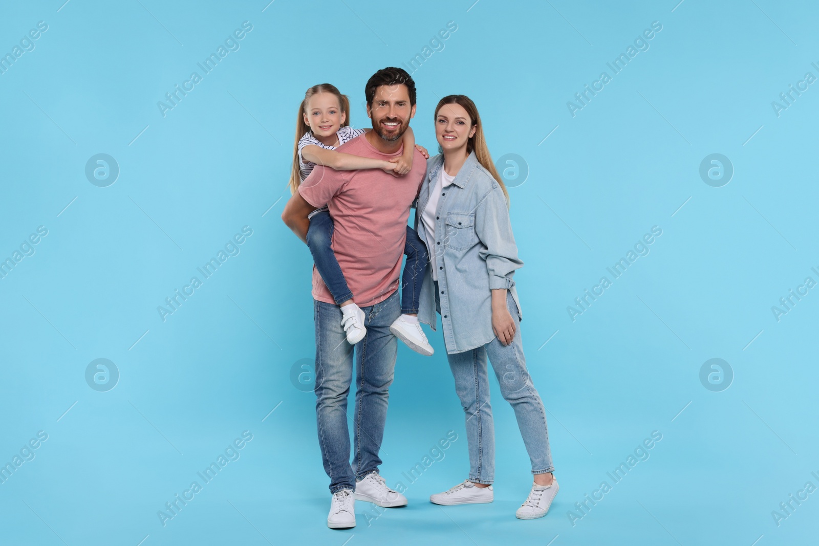 Photo of Happy family together on light blue background