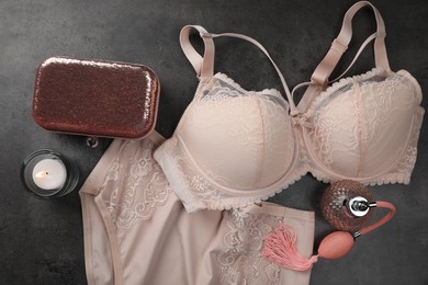 Elegant beige plus size women's underwear, perfume, clutch and candle on grey background, flat lay