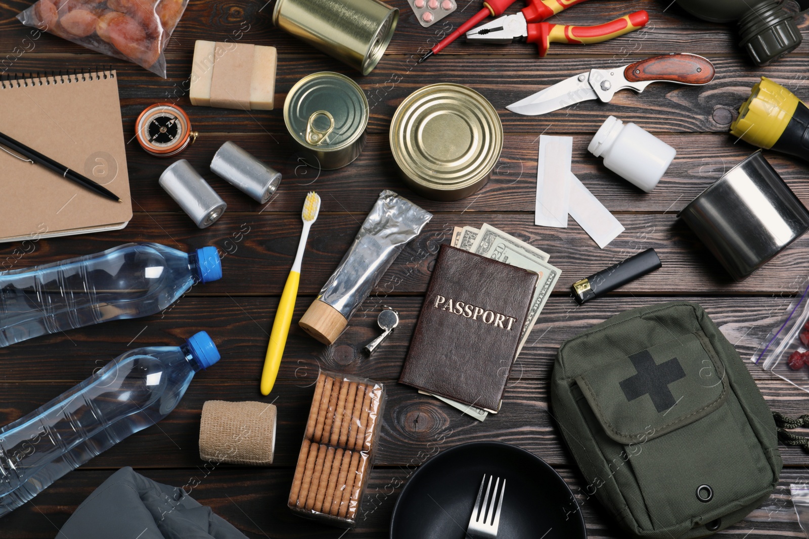 Photo of Disaster supply kit for earthquake on wooden table, flat lay