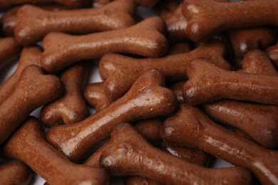 Photo of Many bone shaped dog cookies on white background, closeup