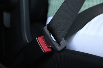 Photo of Driver with fastened safety belt in car, closeup
