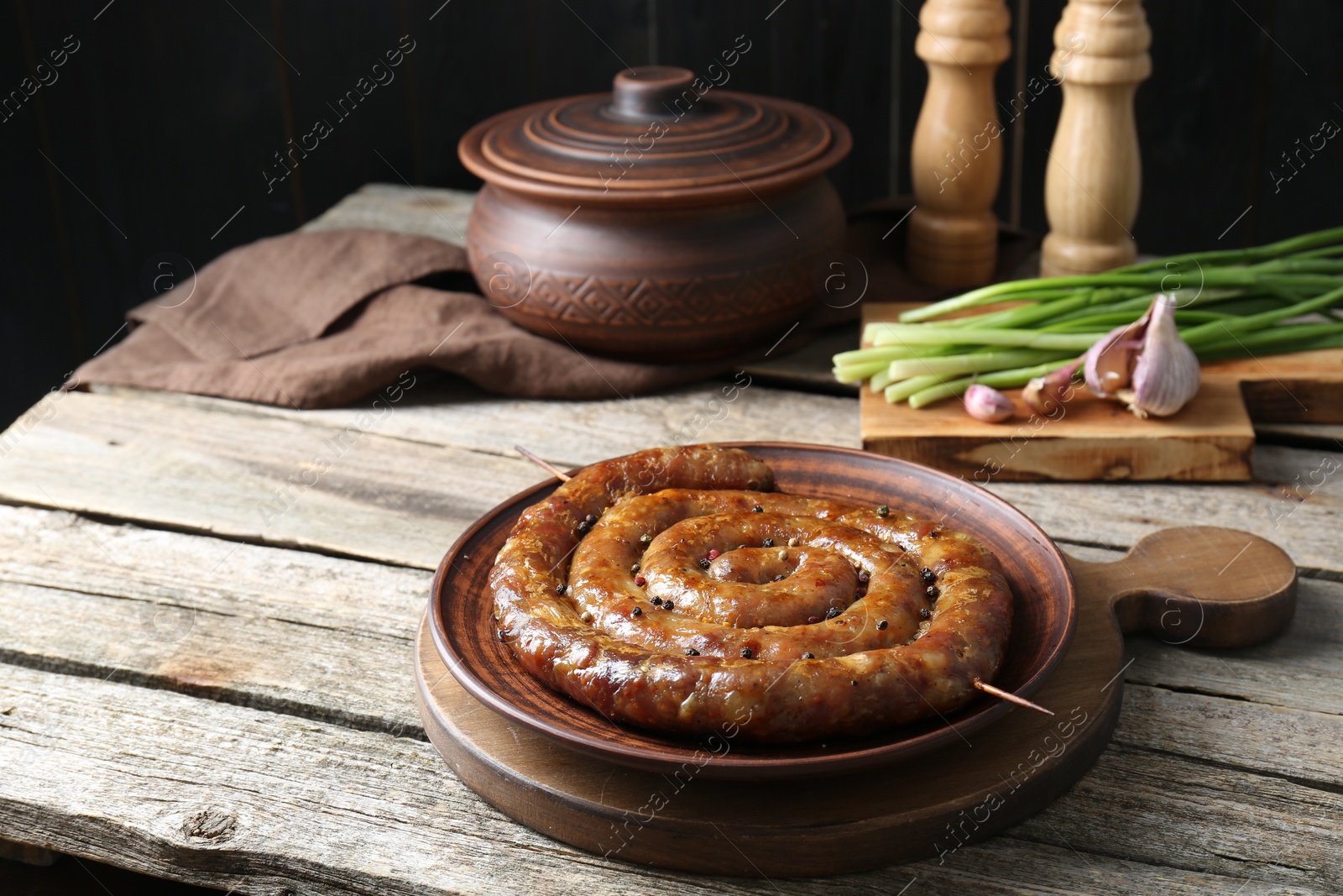 Photo of Plate with tasty homemade sausages on wooden table, space for text