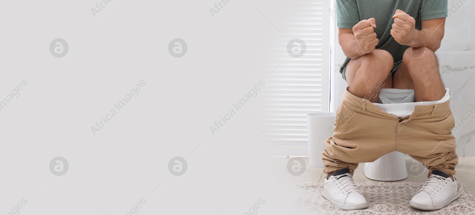 Image of Closeup view of man suffering from hemorrhoid on toilet bowl in rest room, space for text. Banner design