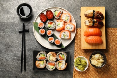 Photo of Flat lay composition with delicious sushi rolls on dark grey table