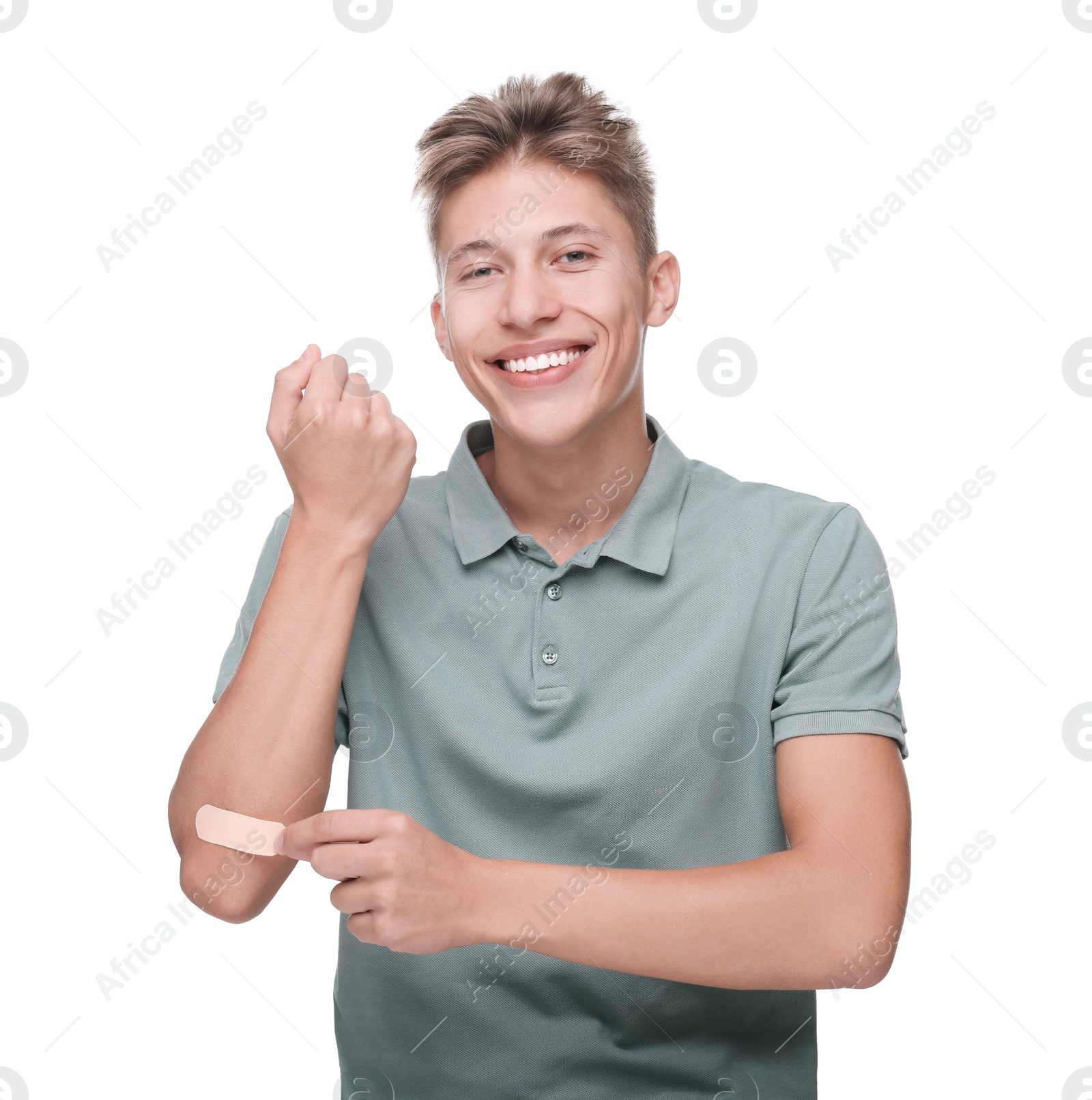 Photo of Handsome man putting sticking plaster onto elbow on white background