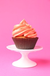 Photo of Delicious cupcake with bright cream on pink background