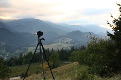 Photo of Taking video with modern camera on tripod in mountains