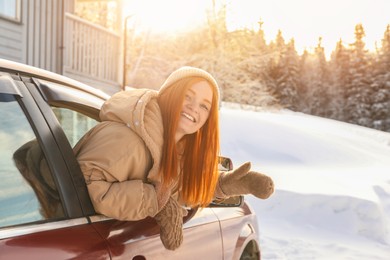 Photo of Happy woman looking out of car window, space for text. Winter vacation