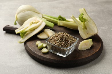 Photo of Fennel seeds in bowl and fresh vegetables on gray table