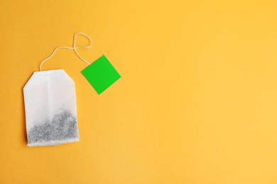 Tea bag on color background, top view with space for text