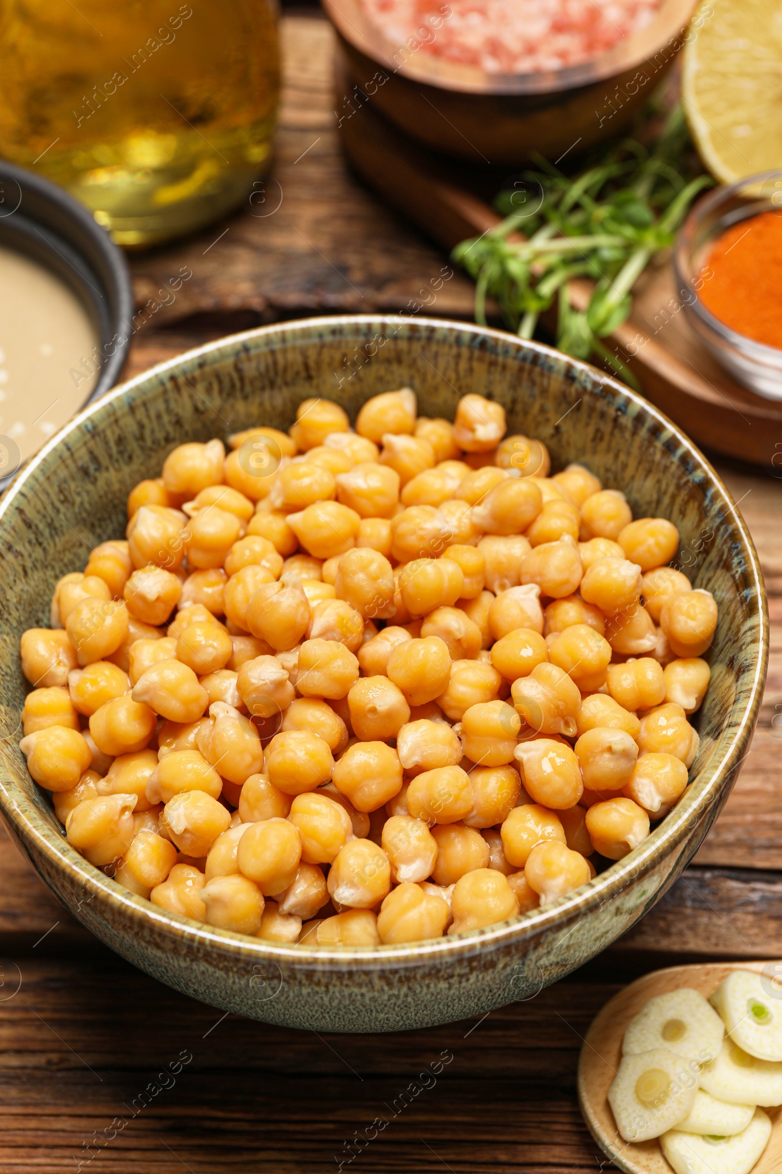 Photo of Delicious chickpeas on wooden table, closeup. Hummus ingredient