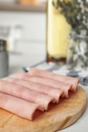 Photo of Slices of tasty ham on white wooden table
