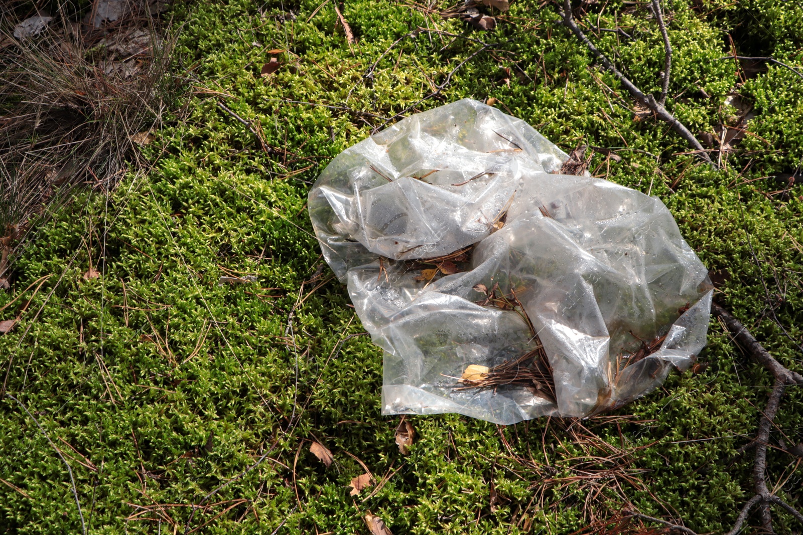 Photo of Disposable polyethylene bag on grass outdoors, top view. Recycling problem