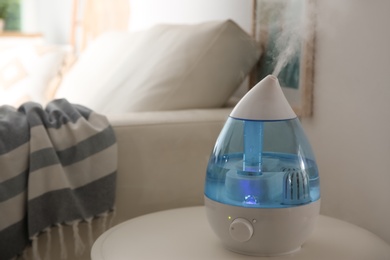 Modern humidifier on table indoors. Space for text