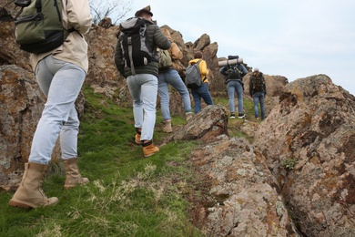 Photo of Group of hikers with backpacks climbing up mountains