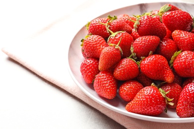 Plate with fresh ripe strawberries on table, closeup