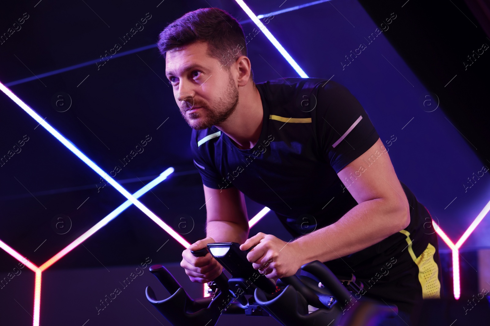 Photo of Man training on exercise bike in fitness club