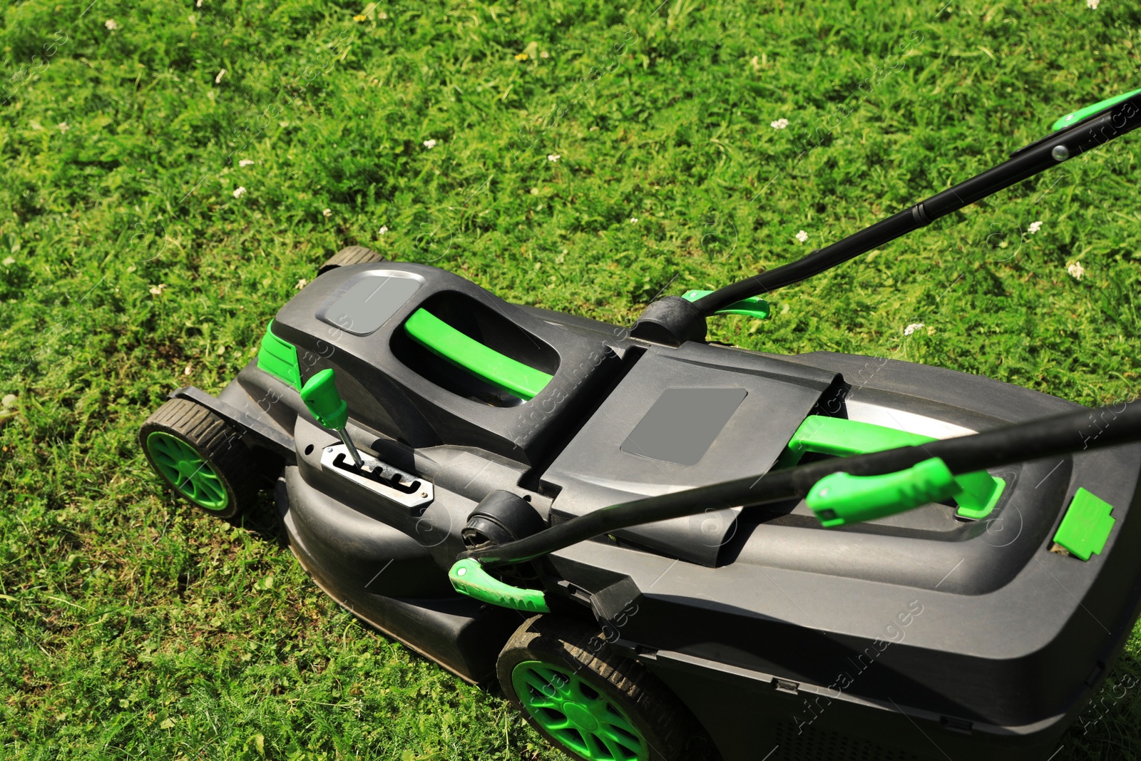 Photo of Lawn mower on green grass in garden